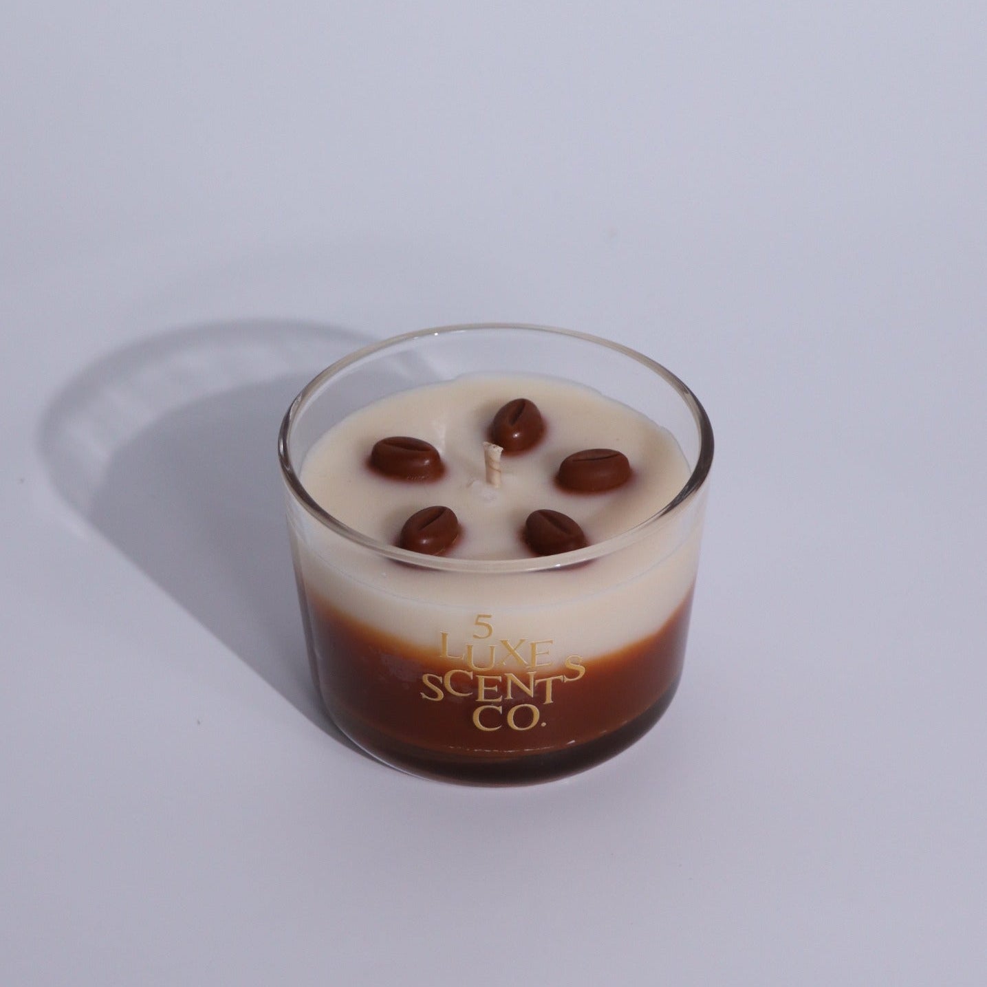 Glass candle with chocolate chips on a white background