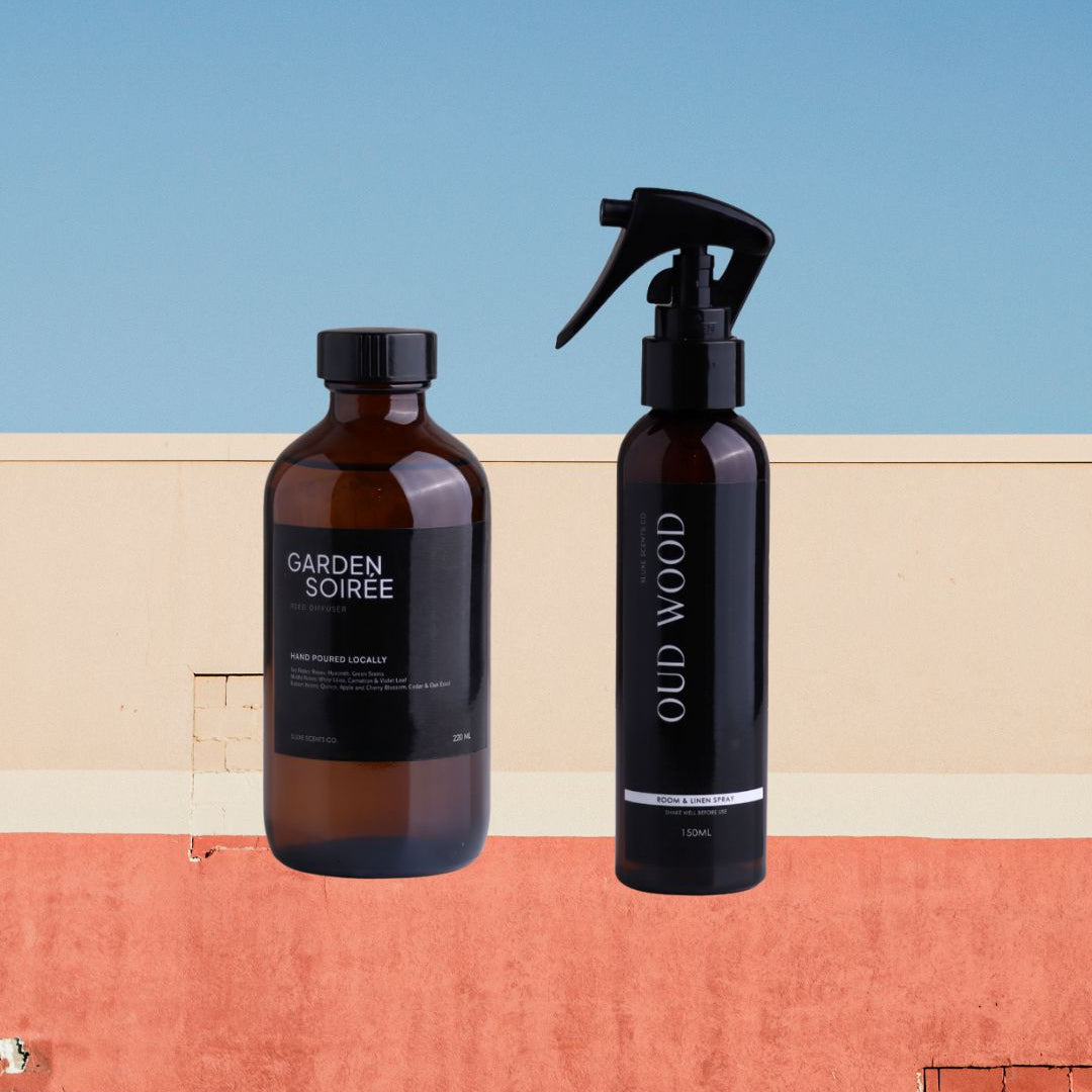 Two bottles of 'Garden Soiree' and 'Old Wood' on a colorful geometric background