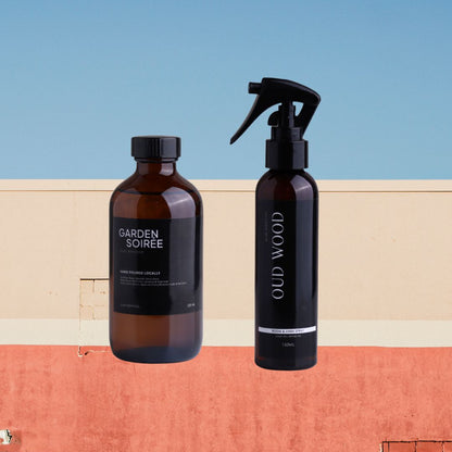 Two bottles of 'Garden Soiree' and 'Old Wood' on a colorful geometric background