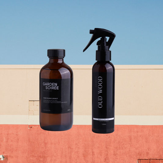 Two bottles of 'Garden Soiree' and 'Old Wood' on a colorful geometric background