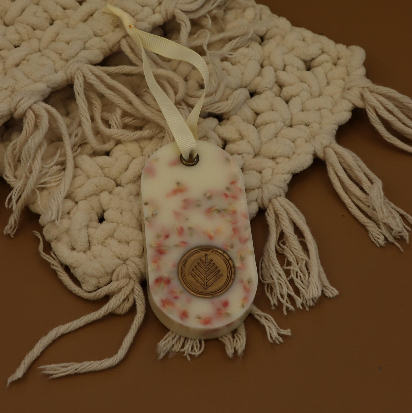 Small shoe with floral pattern and button on a textured fabric background