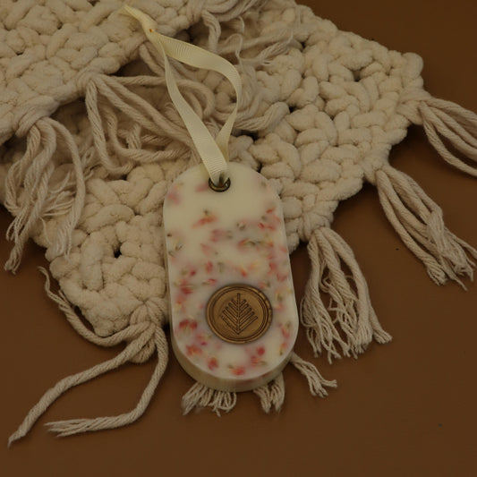 Small shoe with floral pattern and button on a textured fabric background